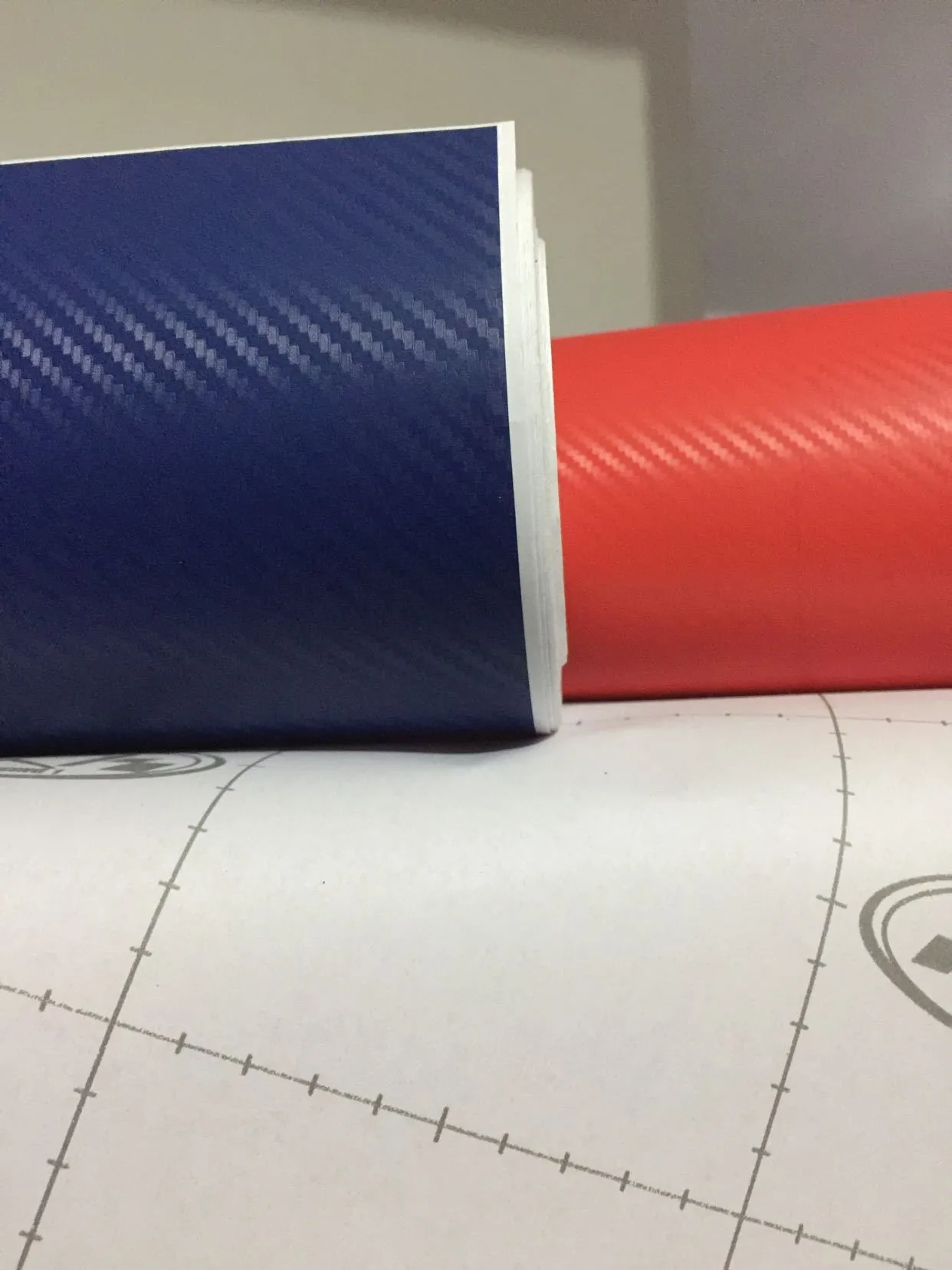 3D carbon fibre car sticker roll in black with textured pattern on a white background