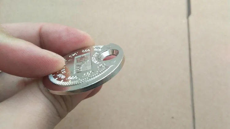 Round zinc alloy spark plug gauge with dual scales on a white background