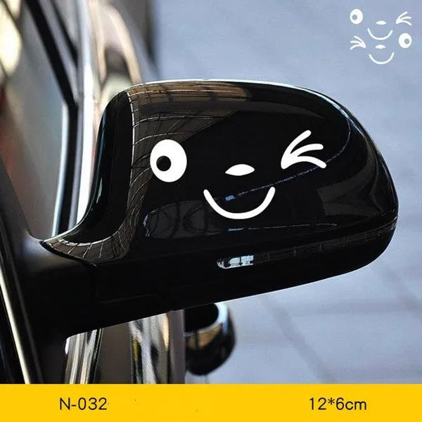 Pair of reflective cartoon car stickers with cute eyes on a car rearview mirror.