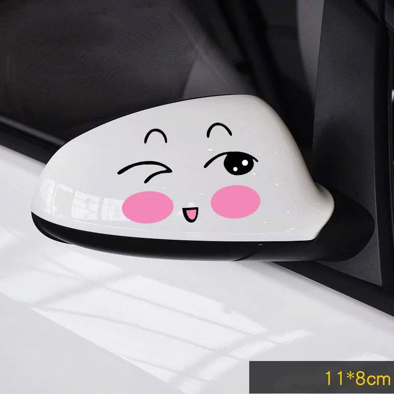 Pair of reflective cartoon car stickers with cute eyes on a car rearview mirror.