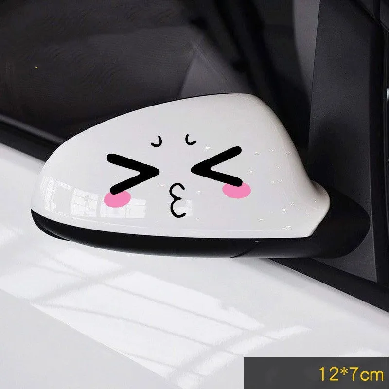 Pair of reflective cartoon car stickers with cute eyes on a car rearview mirror.