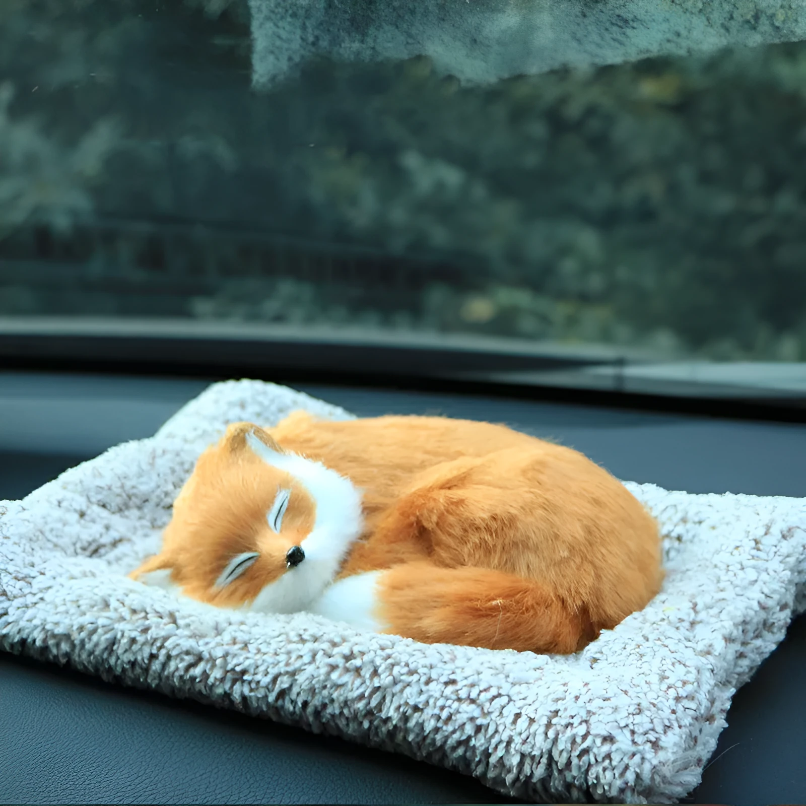 Fox bamboo charcoal car deodorant doll with grey hair and check pad on a car dashboard
