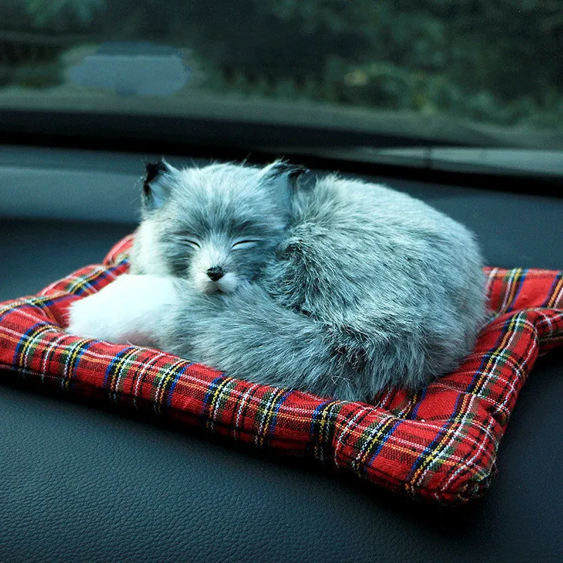 Fox bamboo charcoal car deodorant doll with grey hair and check pad on a car dashboard
