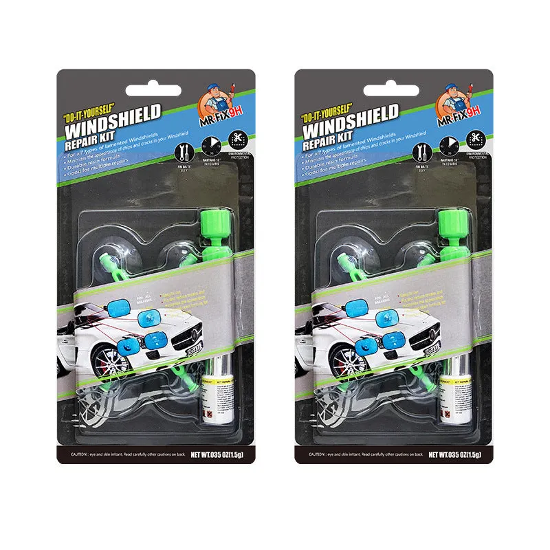 Windshield repair fluid kit with green resin, repair device, curing strips, and sleeved razor blade on a car windscreen