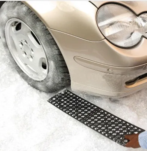 Pair of black rubber car recovery plates on a muddy ground, each 55×15 cm, for self-rescue from soft terrain