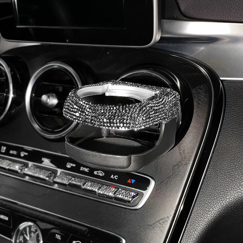 White diamond-decorated car cup holder bracket clipped onto a vehicle air vent.
