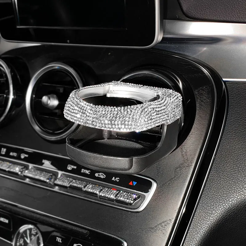 White diamond-decorated car cup holder bracket clipped onto a vehicle air vent.