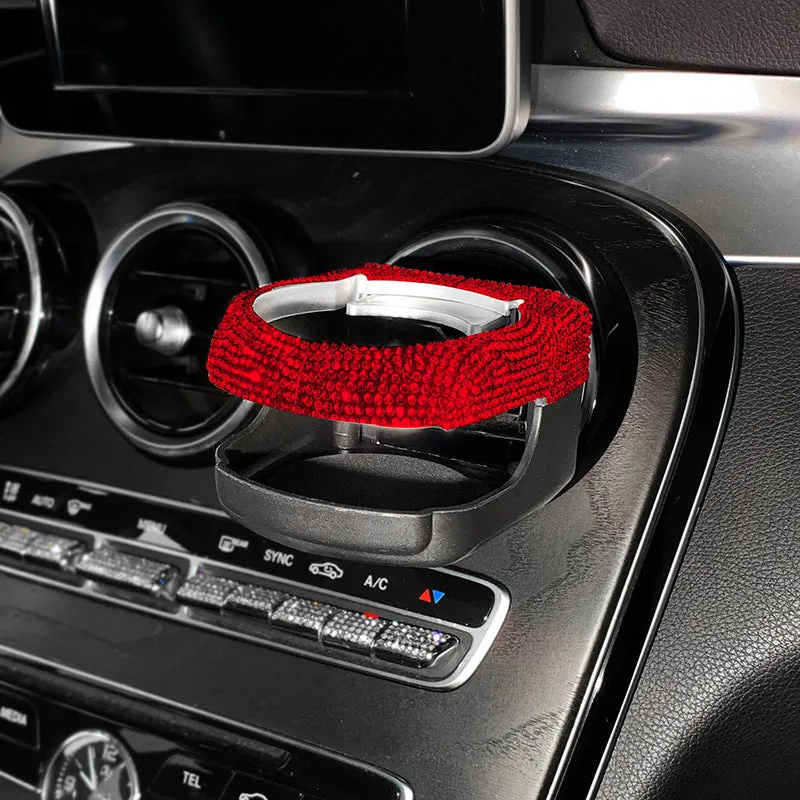 White diamond-decorated car cup holder bracket clipped onto a vehicle air vent.