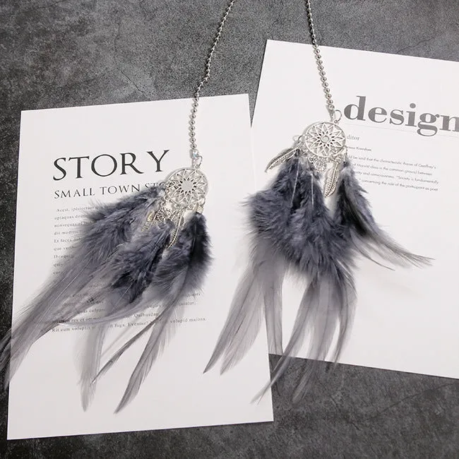 Dreamcatcher car ornament with metal frame and feather in one of six colours on car interior