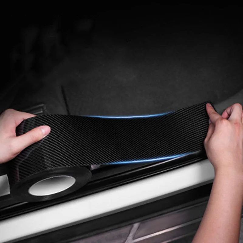 Black carbon fiber self-adhesive anti-collision decorative strip roll for car door threshold and bumper edge protection.