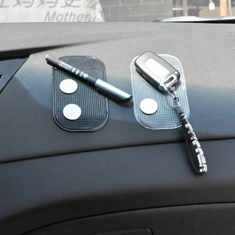 Black silicone car anti slip mat with spider-web texture, 13x7cm, on a car dashboard holding a smartphone
