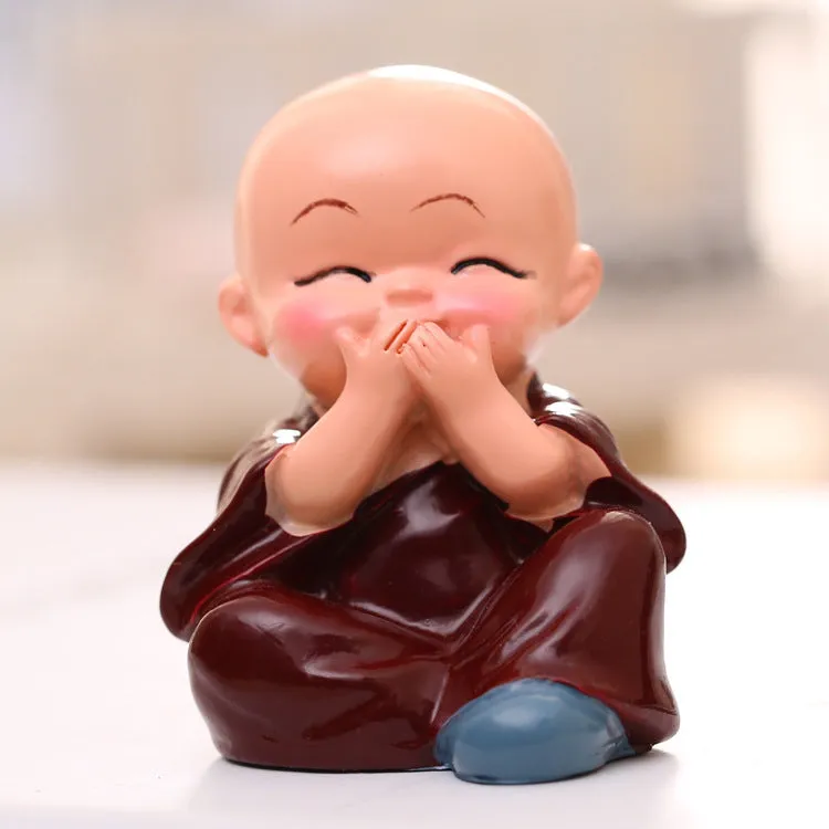 Set of 4 miniature resin Buddha monk statues in blue, brown, gray, and orange, 4.7 cm tall, on a shelf