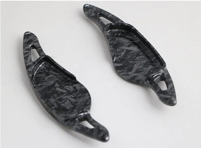 Steering wheel paddle shifters in carbon fibre black finish for manual gear control enhancement