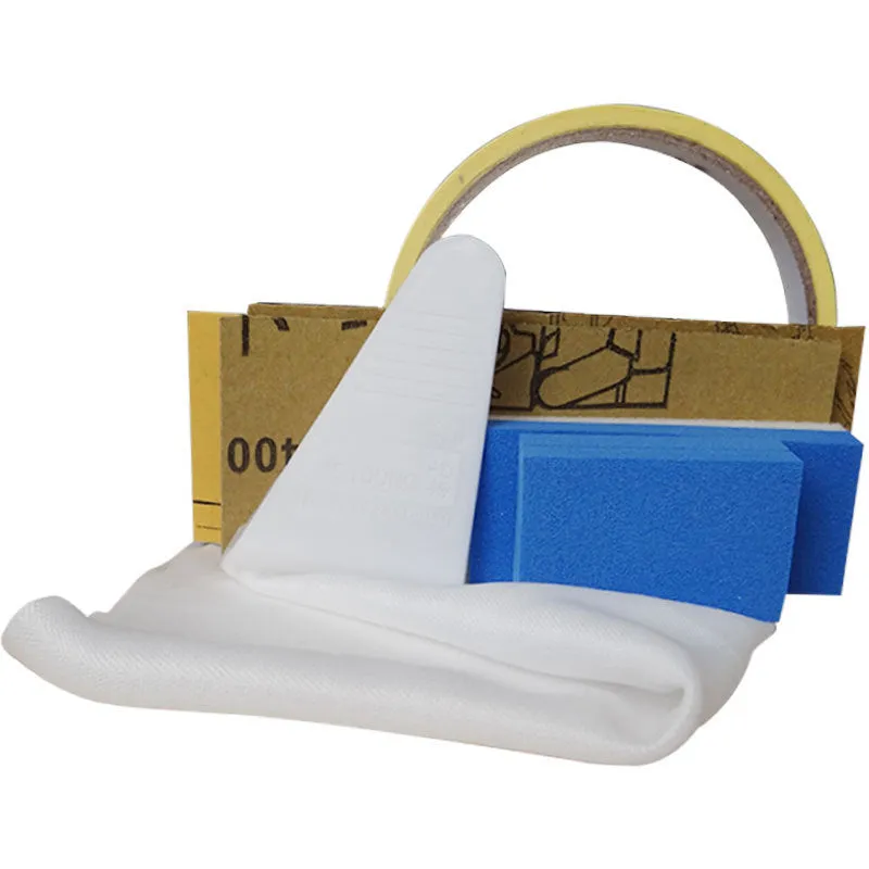 Car scratch repair kit with polishing wax, sandpaper, sponge, cloth, scraper, and brush on workbench