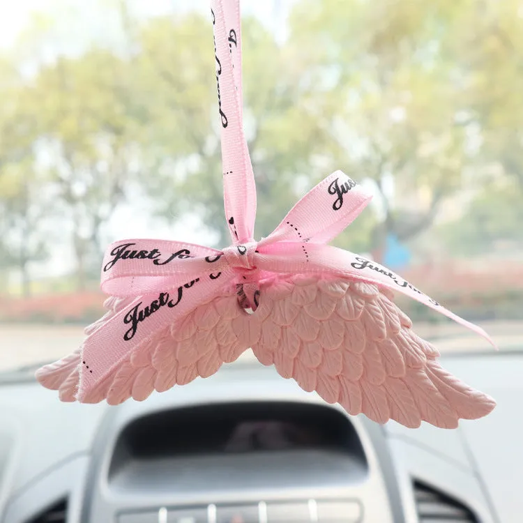 Angel wings gypsum car perfume pendant with black ribbon and white wings hanging from a rearview mirror