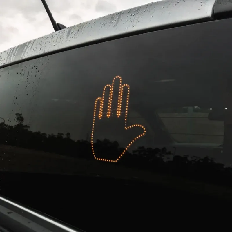 Black LED gesture car light with amber illumination showing hand gesture, remote control, and 3M Velcro mounting