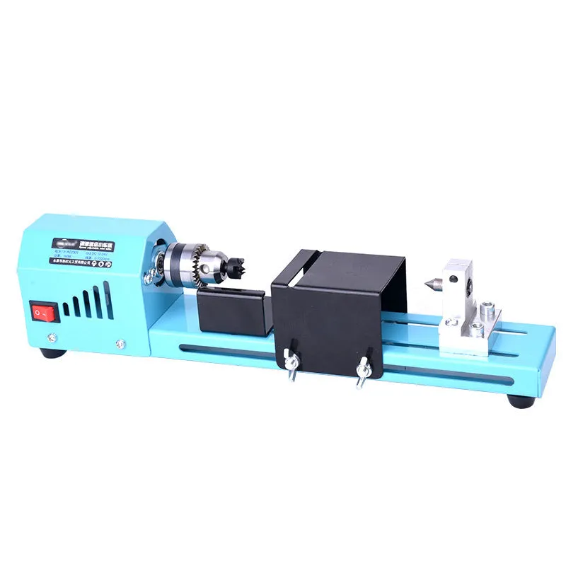 Mini DIY woodworking lathe in blue with protective cover, chuck, and accessories on a white background
