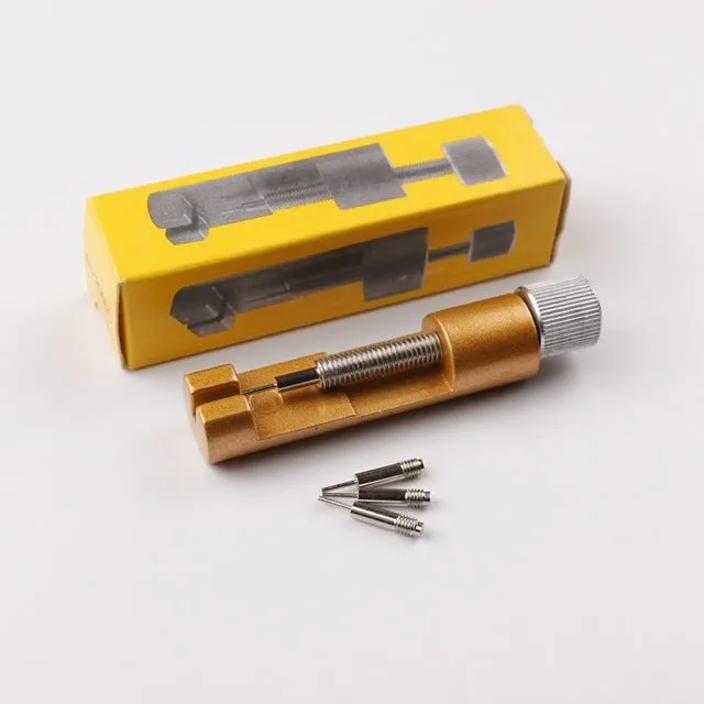 Watch strap link remover tool in black with two thimbles and a metal watch band placed on the detacher groove