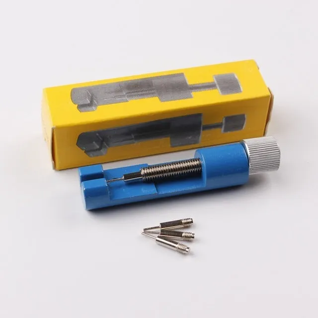 Watch strap link remover tool in black with two thimbles and a metal watch band placed on the detacher groove