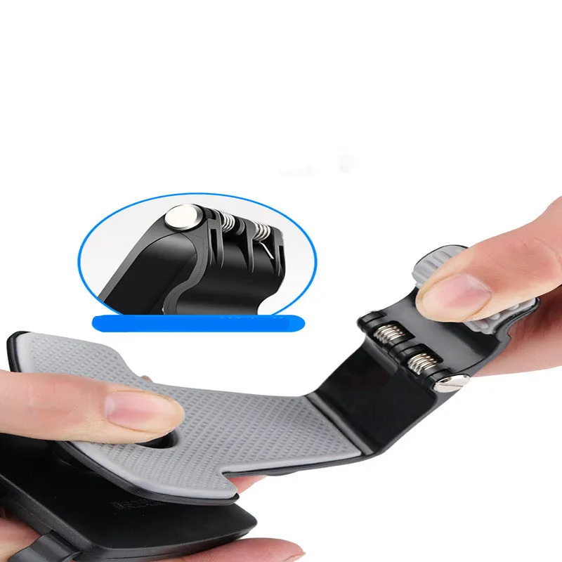 Black car phone holder mounted on dashboard with smartphone in clip
