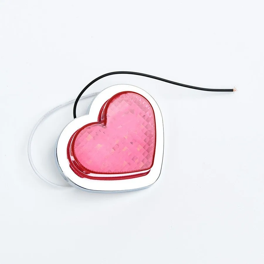 Heart-shaped red LED car fender sidelight on a black background.