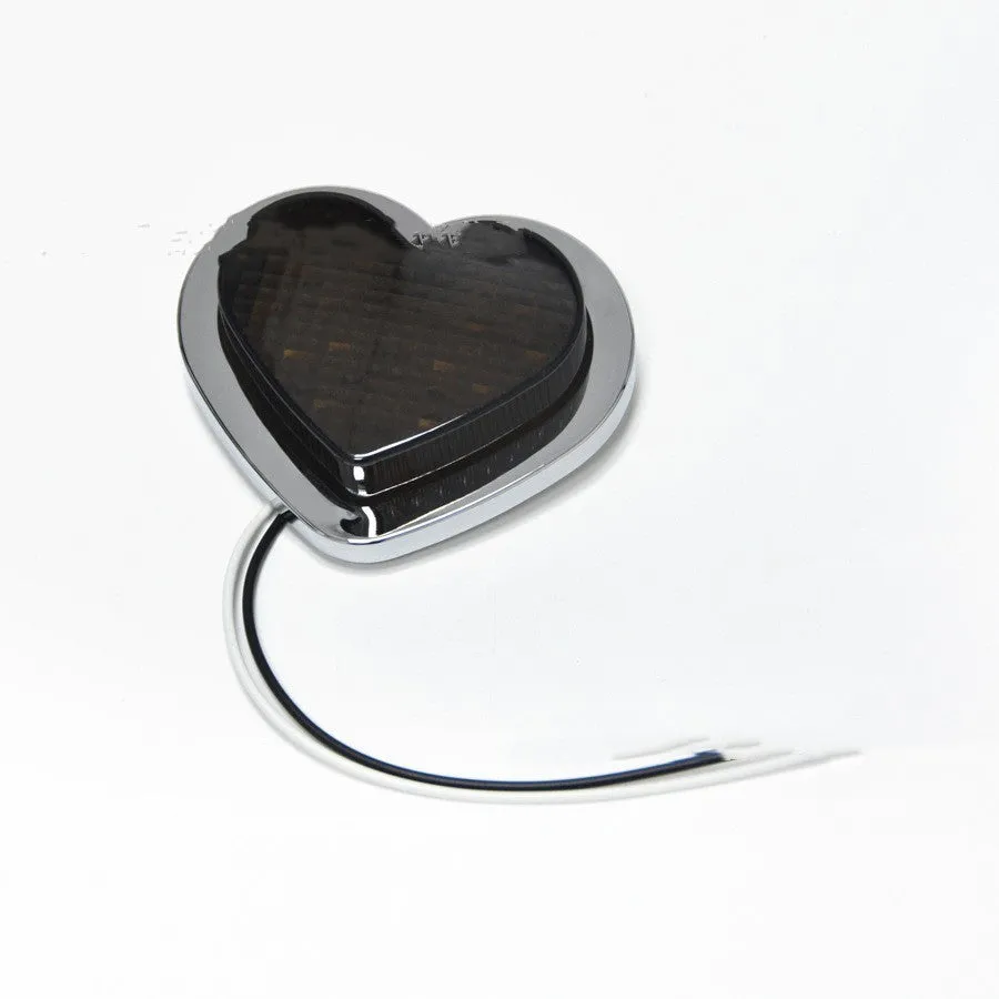 Heart-shaped red LED car fender sidelight on a black background.