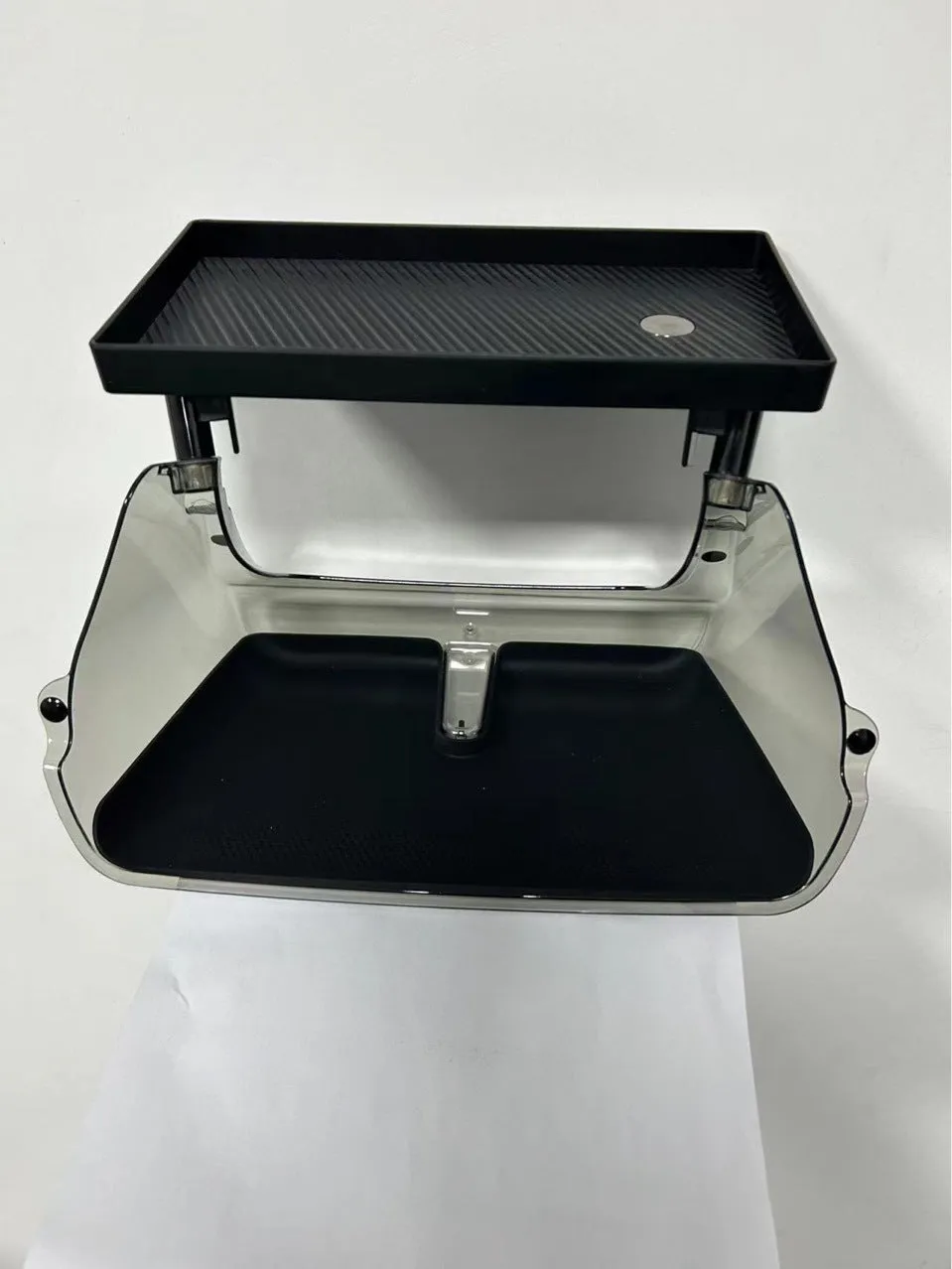 Black ABS plastic storage box fitted under the touchscreen of a Tesla Model Y interior.