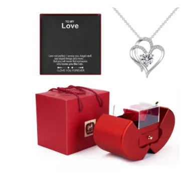 Red apple-shaped jewelry box with eternal soap flower rose and silver necklace inside