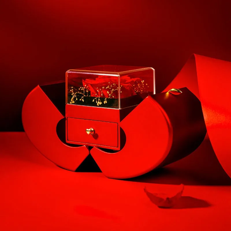 Red apple-shaped jewelry box with eternal soap flower rose and silver necklace inside