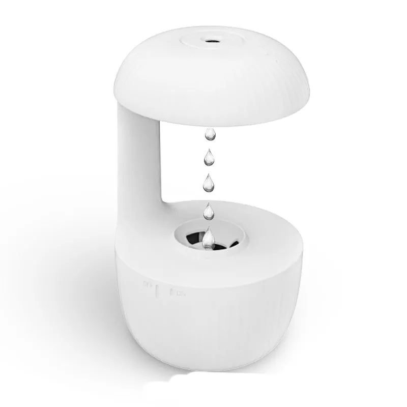 White anti-gravity air humidifier with ultrasonic mist levitating water drops on a desk