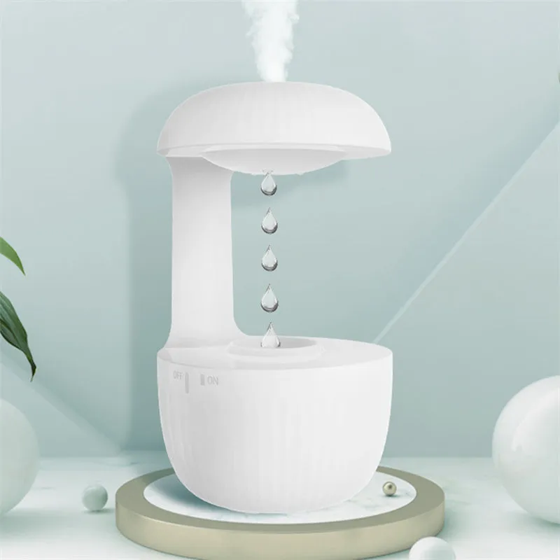 White anti-gravity air humidifier with ultrasonic mist levitating water drops on a desk
