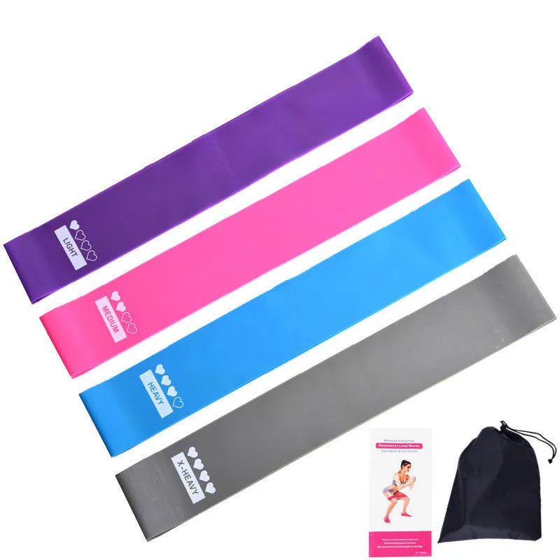 Four colour-coded resistance bands in purple, pink, blue, and grey with non-slip inner lines laid flat on a surface