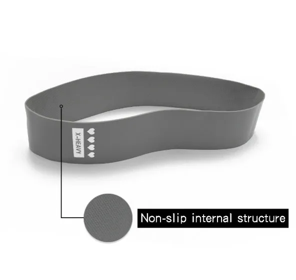 Four colour-coded resistance bands in purple, pink, blue, and grey with non-slip inner lines laid flat on a surface