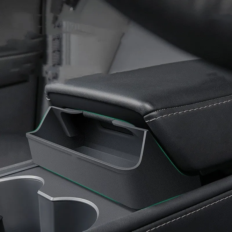 Black silicone sunglasses holder installed in Tesla centre console armrest compartment