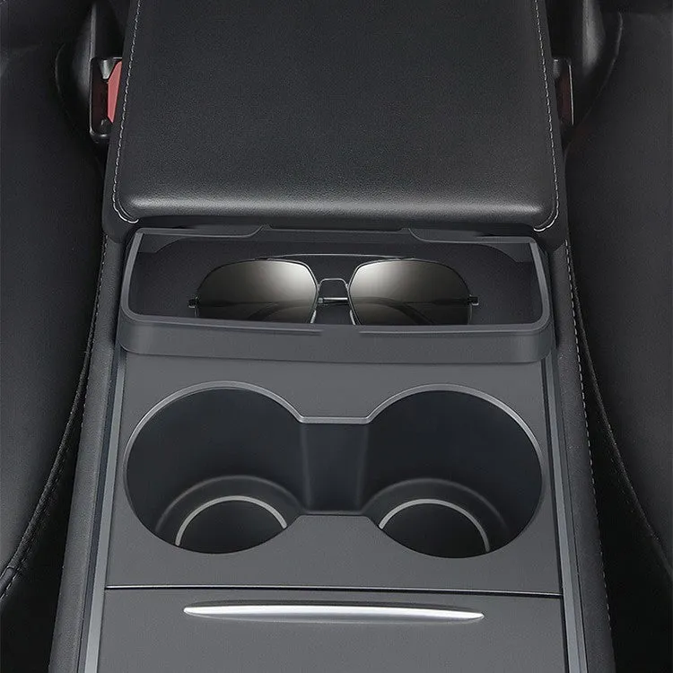 Black silicone sunglasses holder installed in Tesla centre console armrest compartment