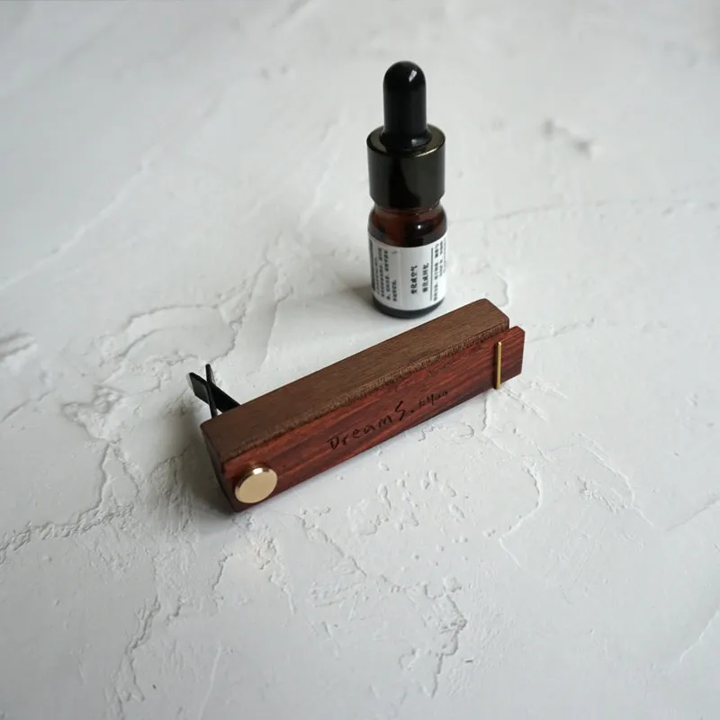 Customisable car perfume ornament diffuser with wood body and brass clip on a car air vent