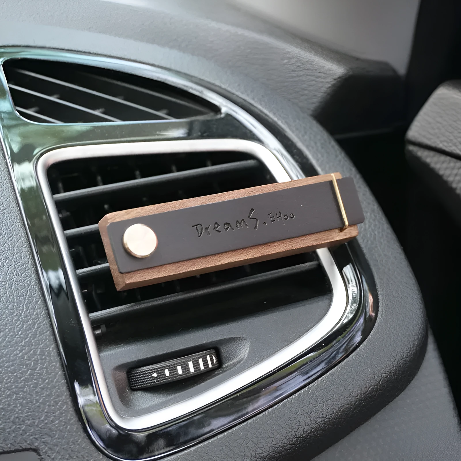 Customisable car perfume ornament diffuser with wood body and brass clip on a car air vent