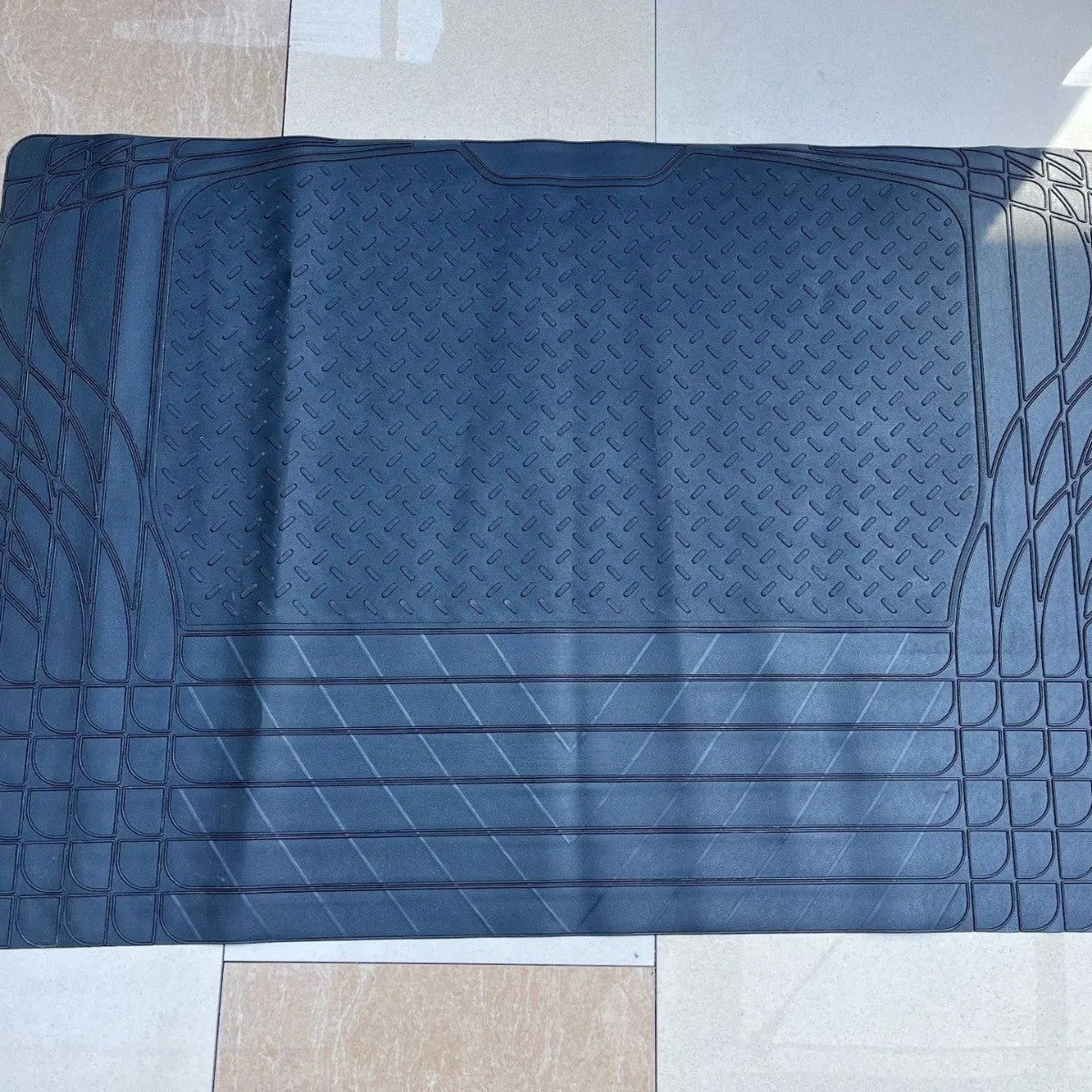 Black universal PVC waterproof car trunk mat in 80x120cm size laid flat on a clean car boot floor