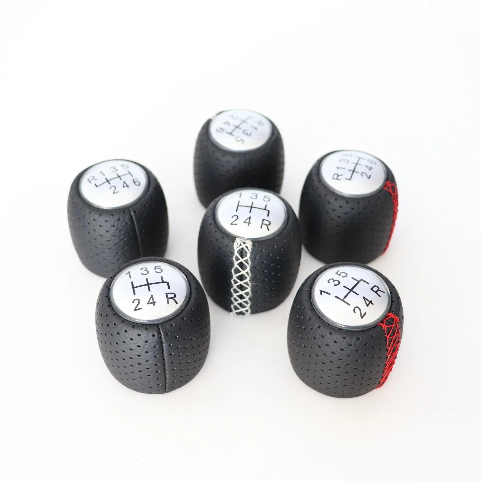 Sewn wrapped perforated leather gear knob for Alpha car in black, red, or white with matte or silver cover.