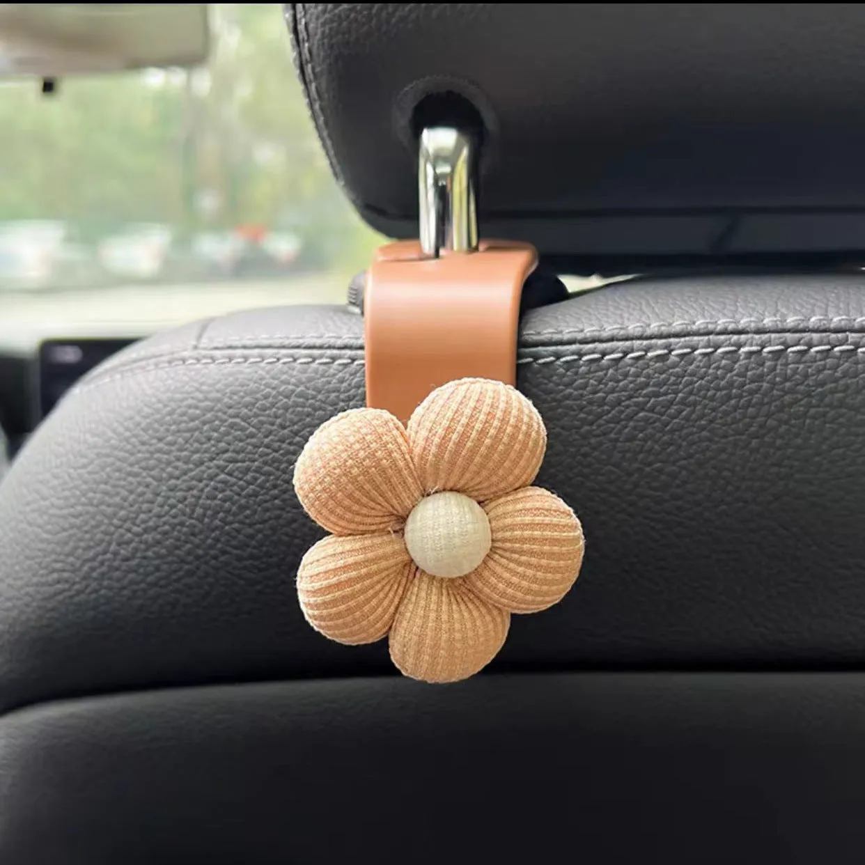Plastic car seat hook in white, 11 by 5.5 cm, hanging from a headrest