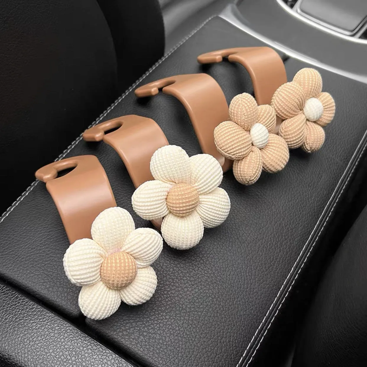 Plastic car seat hook in white, 11 by 5.5 cm, hanging from a headrest