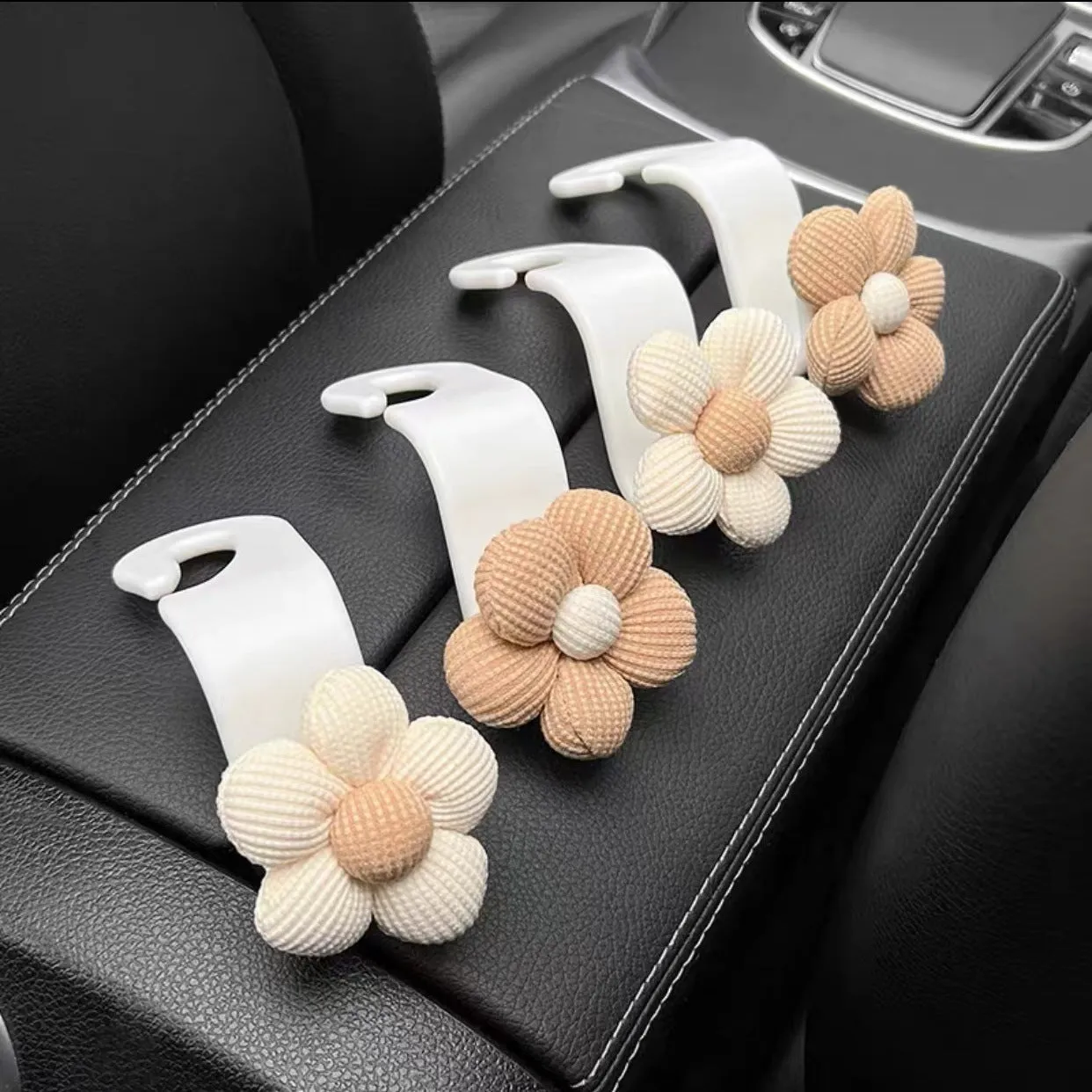 Plastic car seat hook in white, 11 by 5.5 cm, hanging from a headrest