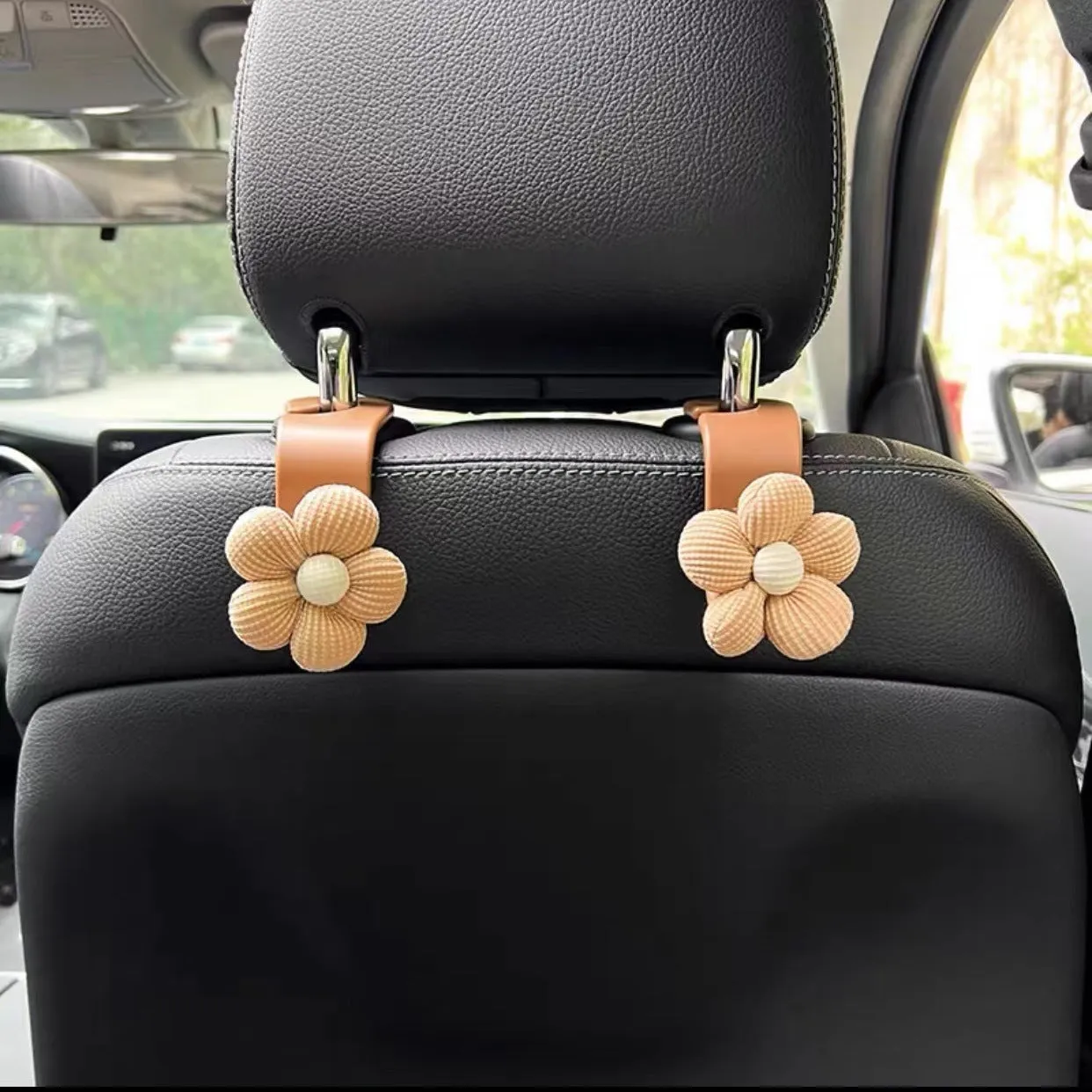 Plastic car seat hook in white, 11 by 5.5 cm, hanging from a headrest