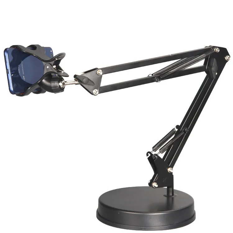 Black universal phone stand with long rotating metal arm and heavy circular base on a wooden desk.