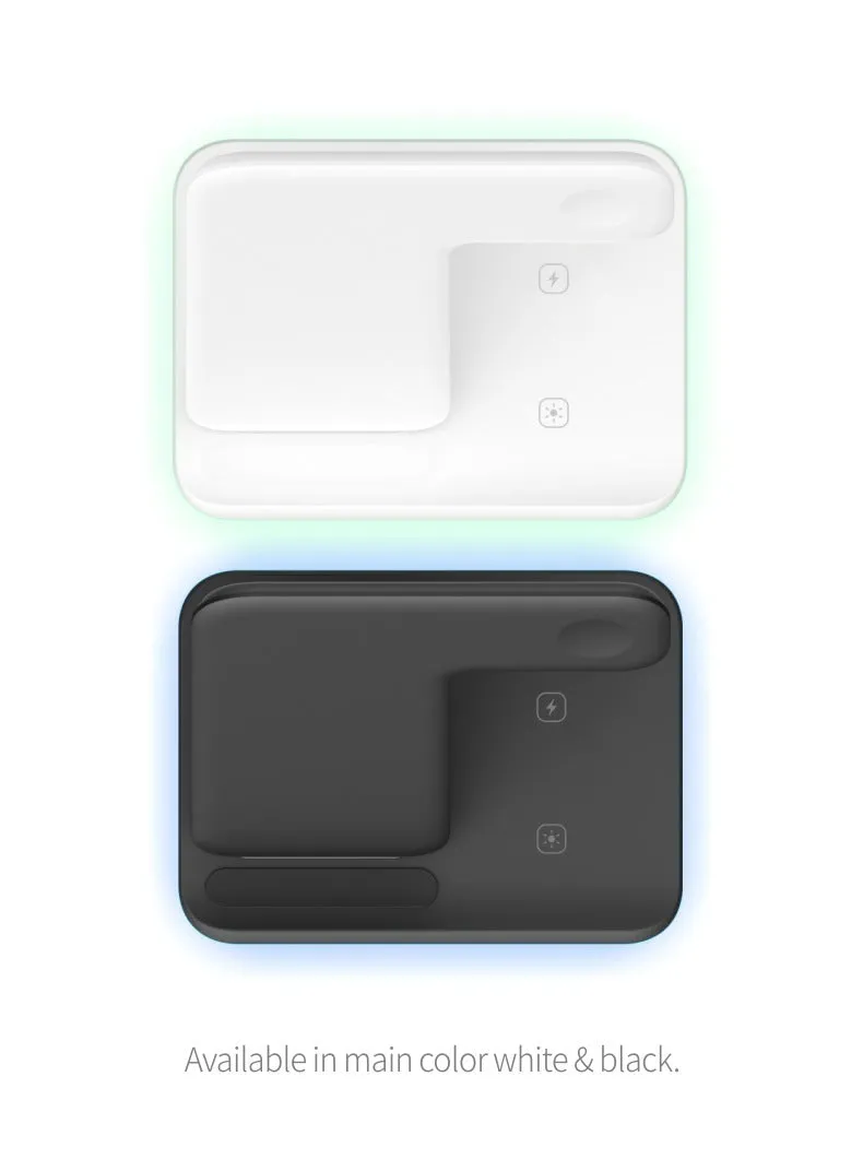 A white three-in-one wireless charging stand on a desk, charging a mobile phone, a smartwatch, and a pair of wireless headphones.
