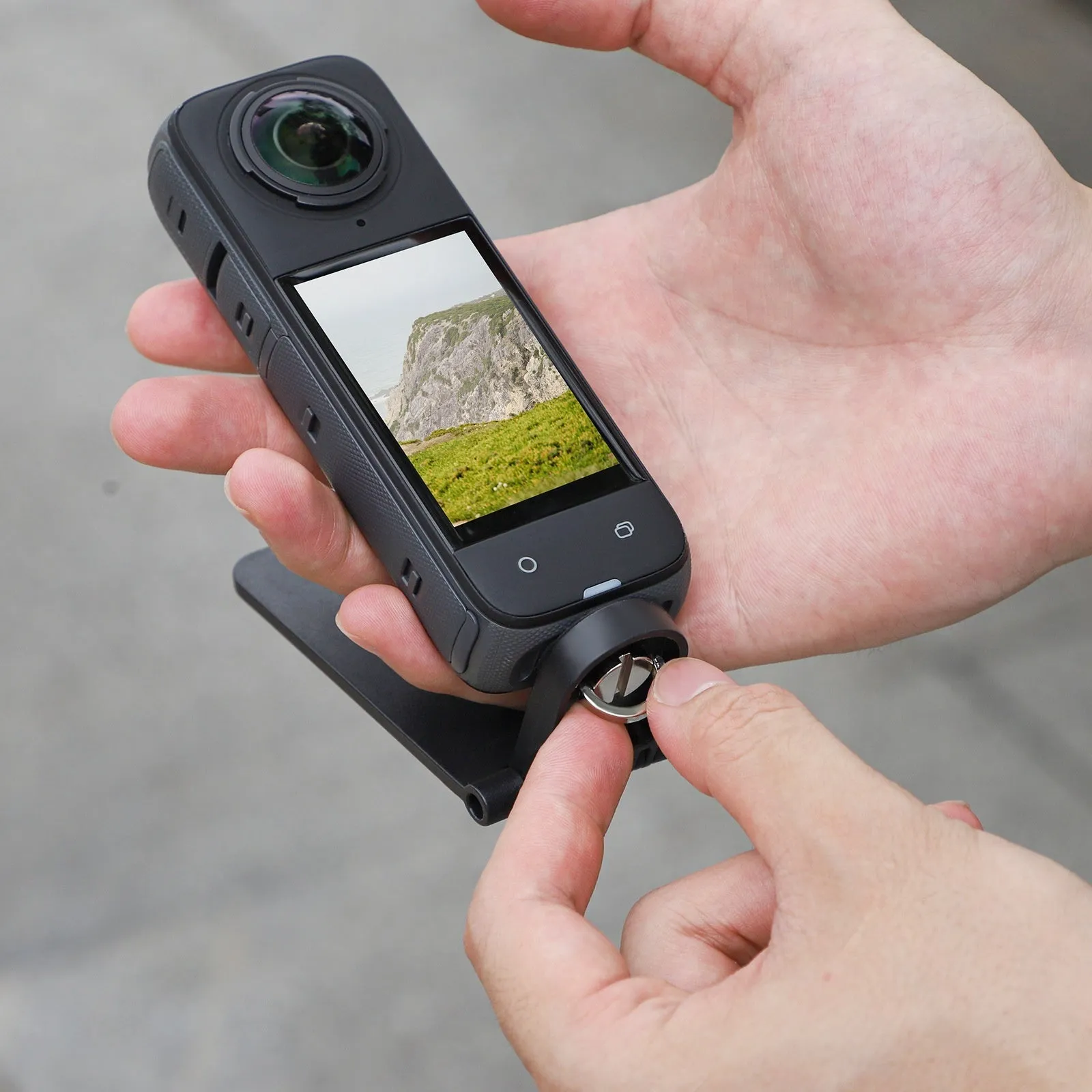 Black magnetic bracket base and handle accessory for Insta360 X4 camera on a desktop
