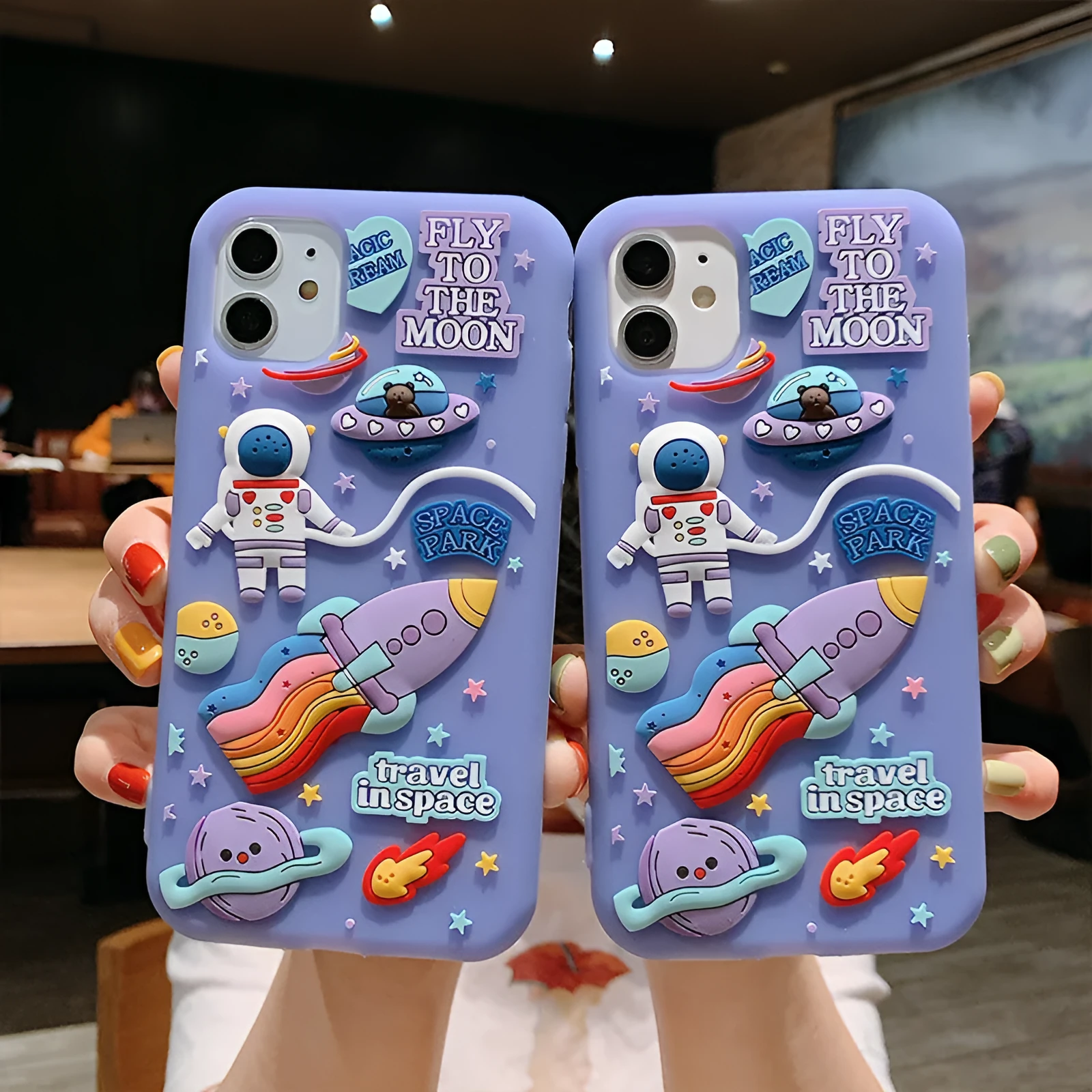 Purple silicone iPhone case with a cartoon astronaut graphic, showing front and back views.