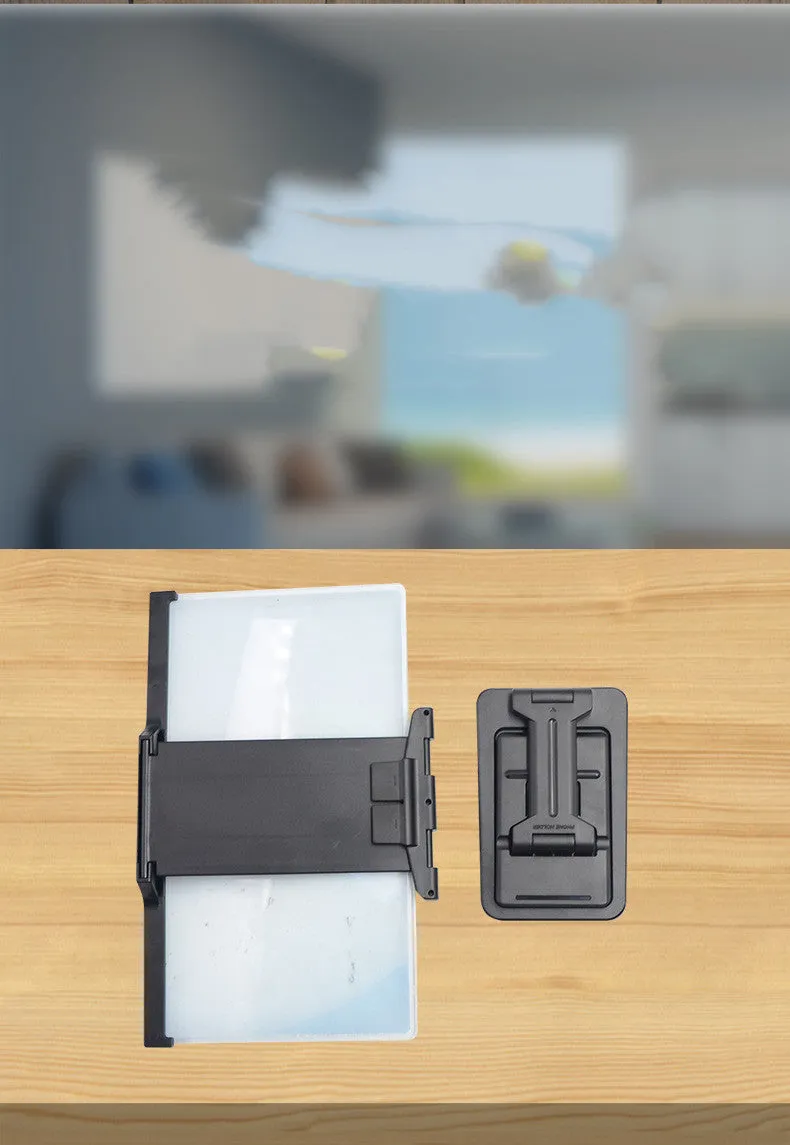 Black folding mobile phone screen amplifier with detached phone holder on a desk