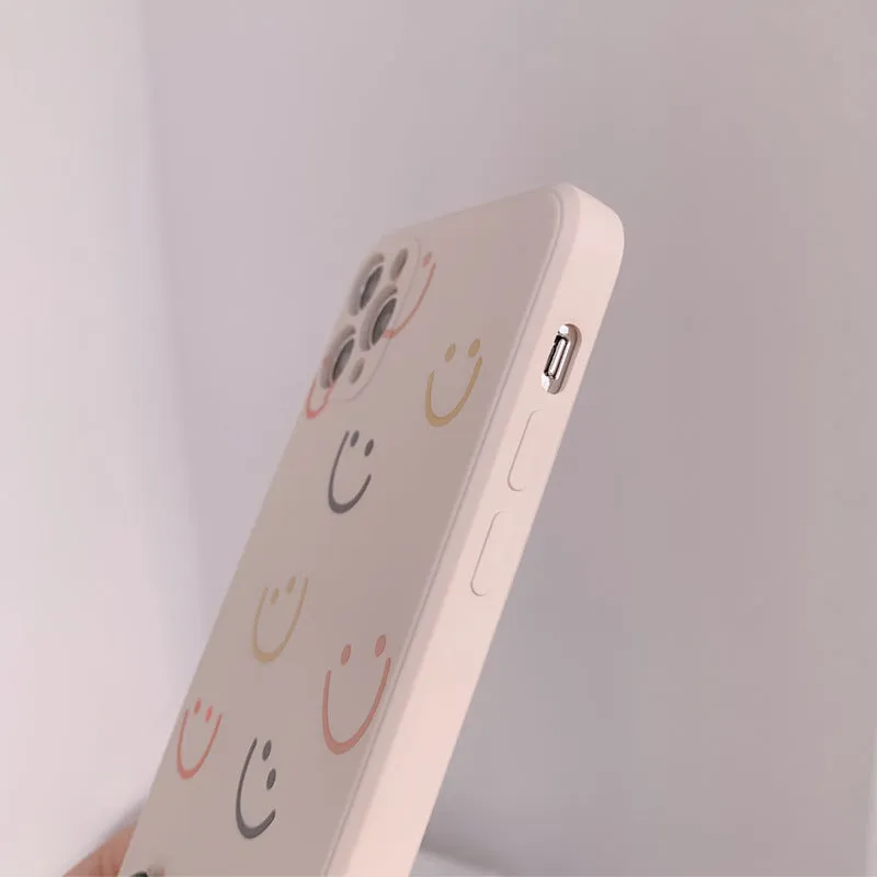 Simple silicone TPU iPhone case with a painted smiley face design on a solid colour background.