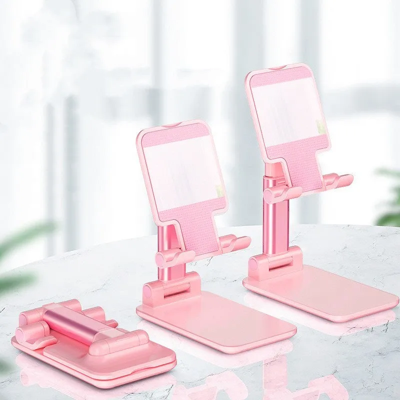 Folding telescopic mobile phone bracket in white, blue, green, or pink colours on a desktop.